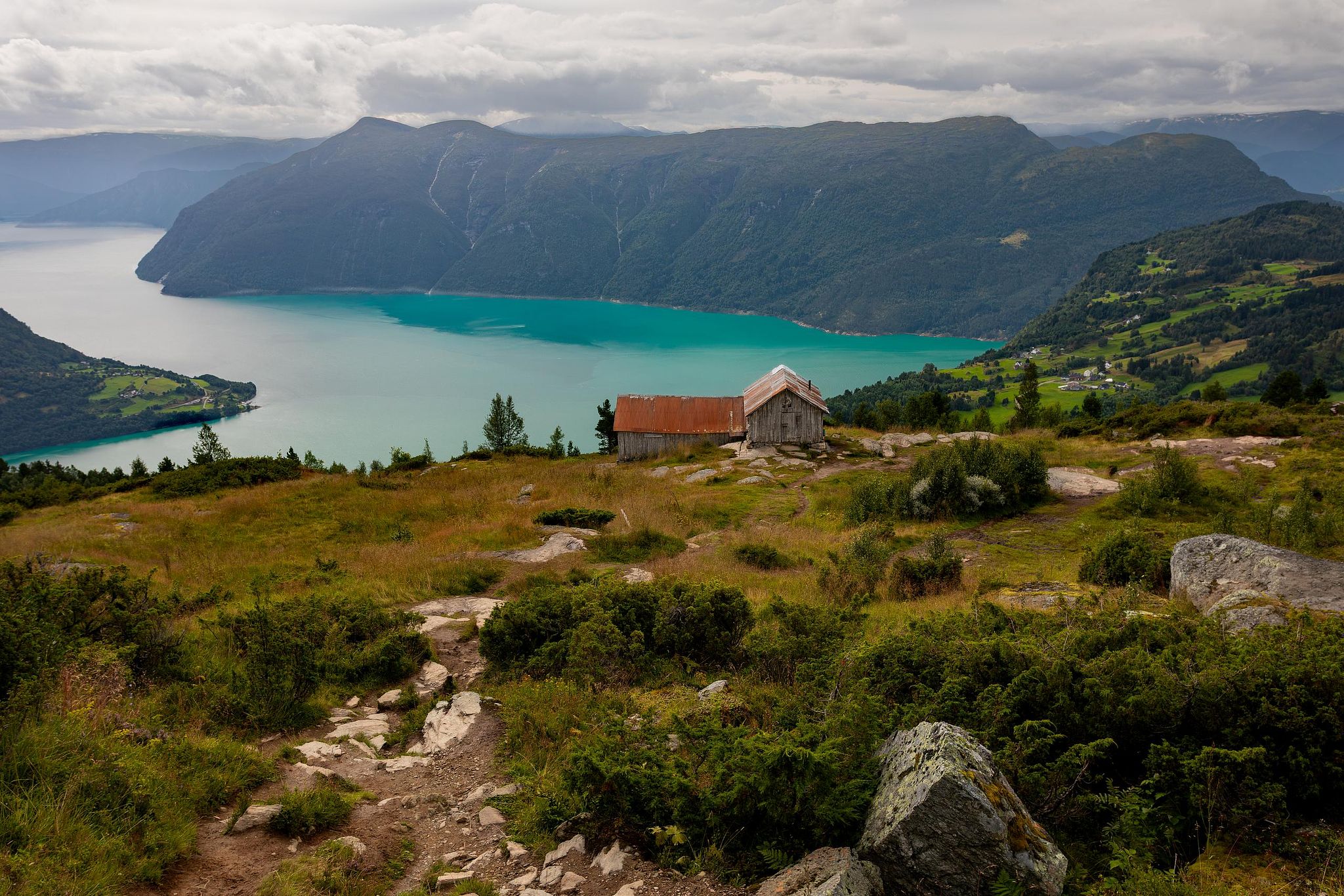 Photographie fine art de lac norvégien turquoise entouré de montagnes, atmosphère paisible.