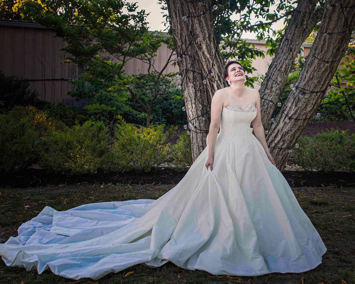 a bride posing under a tree at the mansion in Salisbury, md called poplar hill