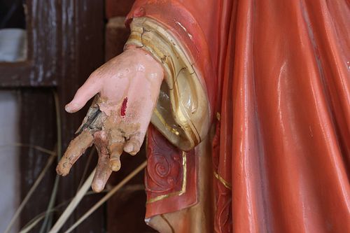 A badly broken hand on the Sacred Heart Statue before restoration
