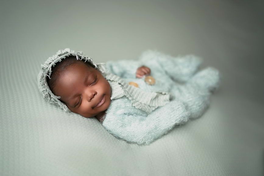 Beautiful baby girl wearing a sleeper captured by Houston Newborn Photographer