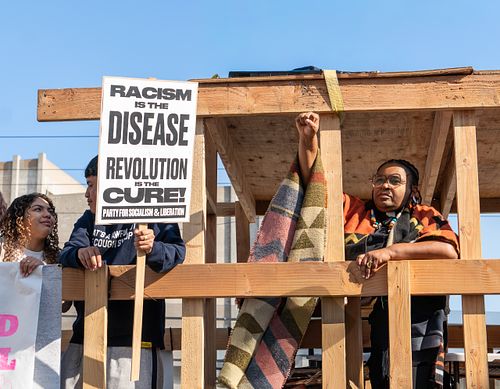 Black woman and latino children protesting for antiracism Los Angeles