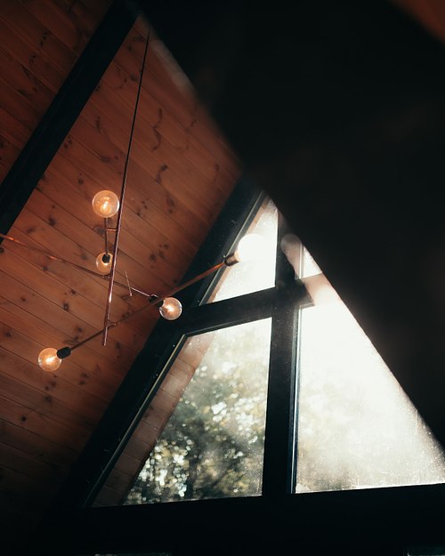 A-frame cabin window with warm wooden interior details