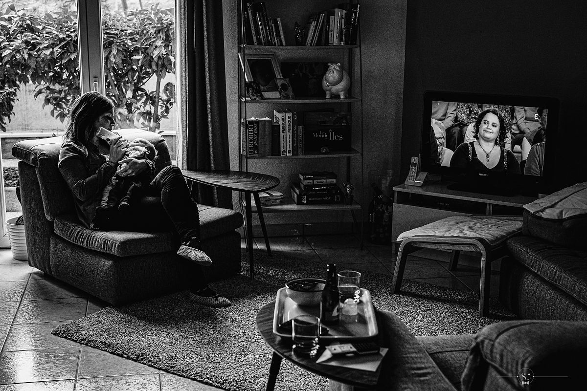 Moment de d&eacute;tente en famille avec une maman donnant le biberon &agrave; son b&eacute;b&eacute; captur&eacute; par photographe de famille &agrave; domicile &agrave; Lyon