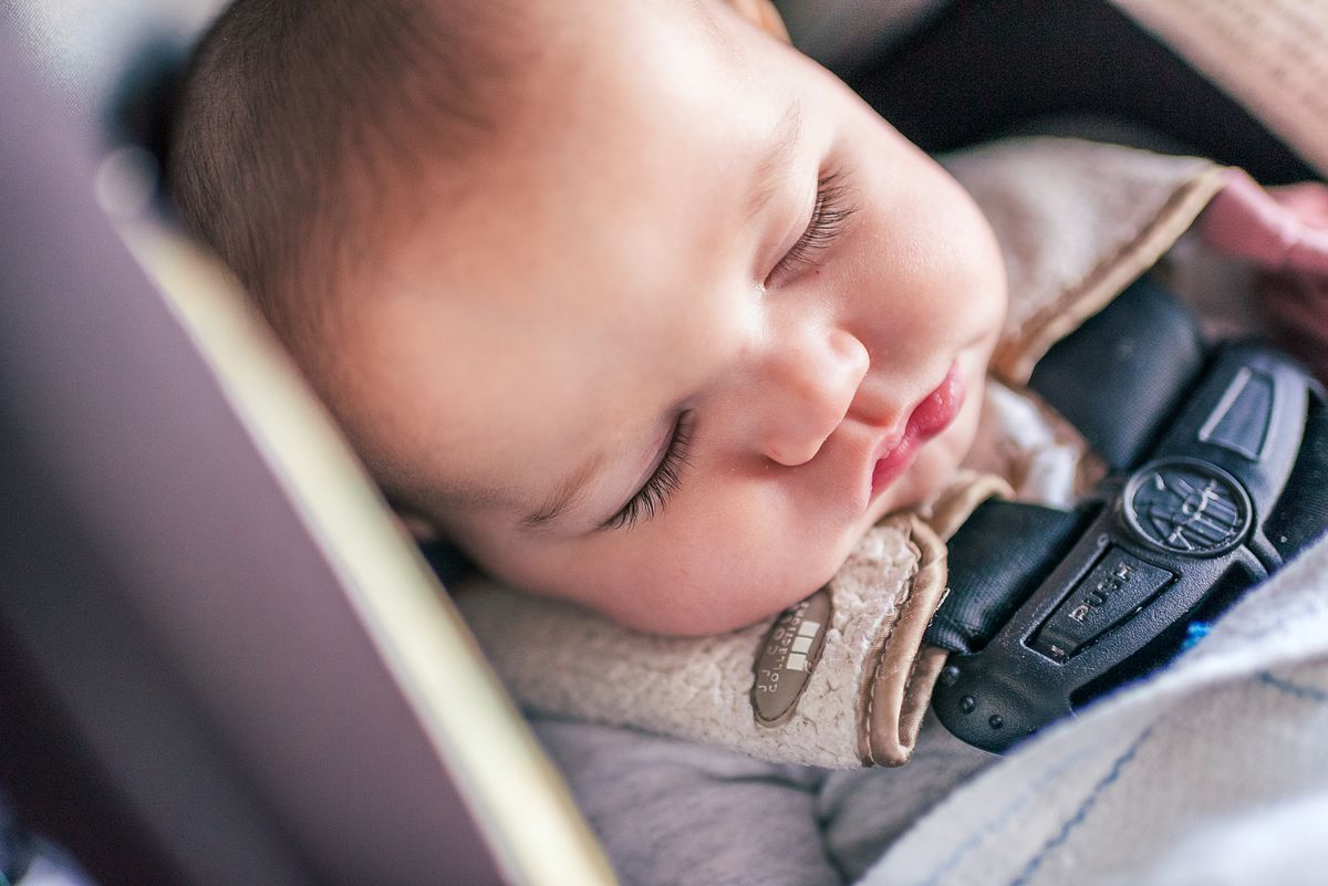 Baby resting peacefully in a car seat during a cross-country road trip with cranberry twp newborn photographer