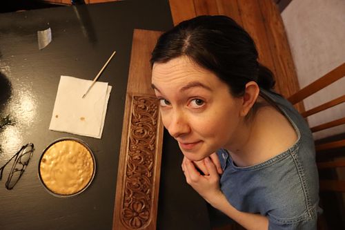Kelly Baker prepares to add gold paint to the baptismal font carved by Wes Baker