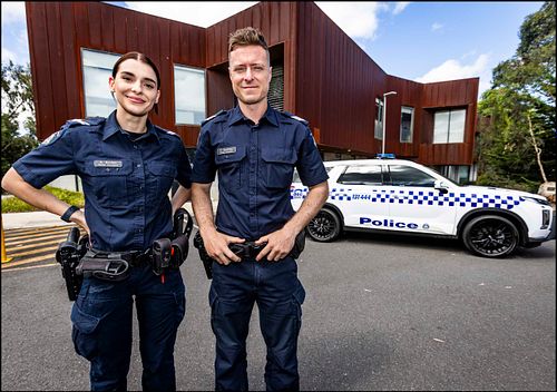 Portrait photo of two police officers outside Somerville Police Station.