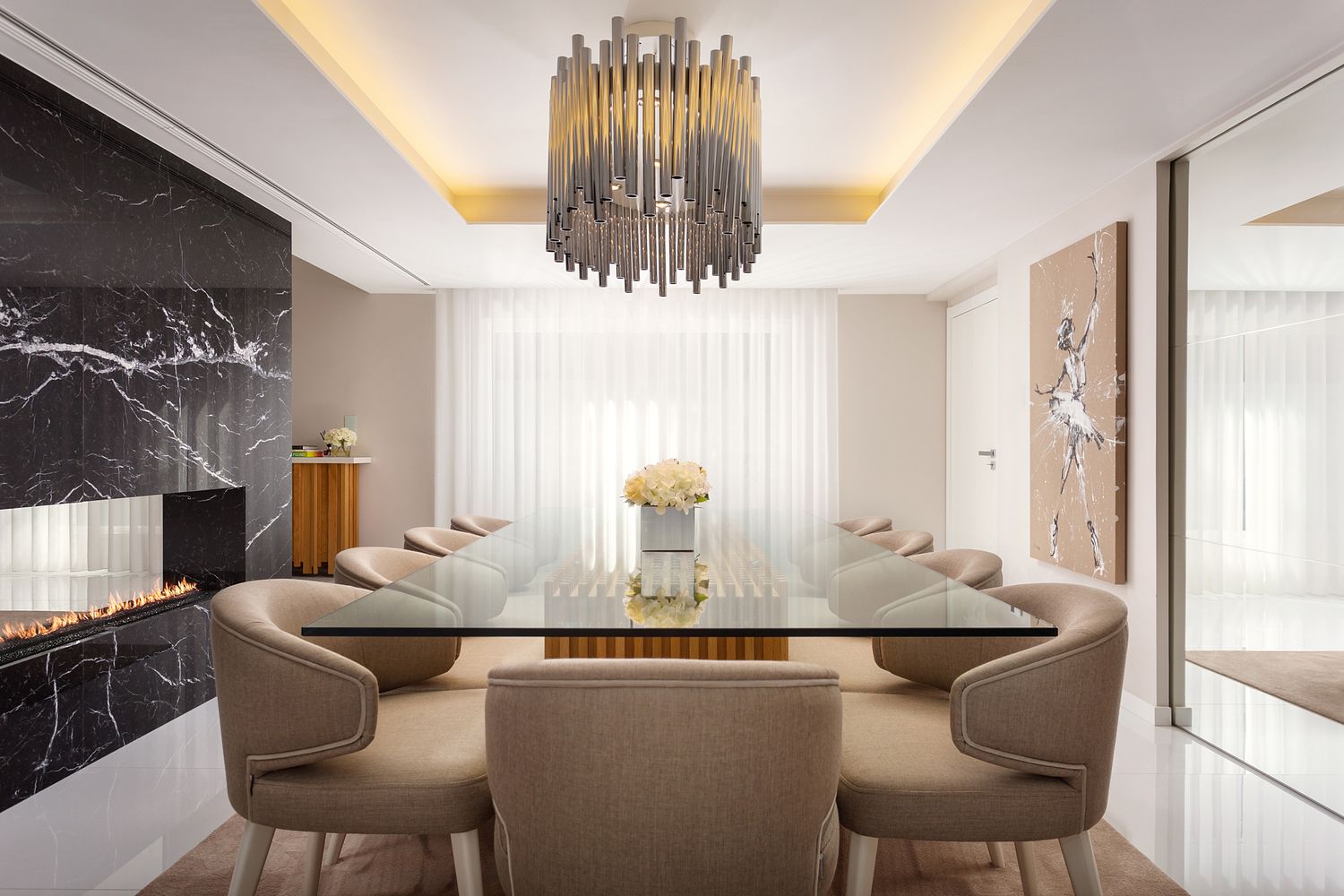 Sala de jantar contemporânea com mesa em vidro e lareira revestida a mármore negro, projeto de interiores por Raquel Lopes Design, fotografada por Pedro Brás Photography — fotografia profissional de design de interiores e decoração residencial em Portugal