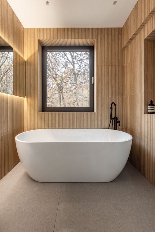 Bathroom interior with forest view, featuring natural textures and soft ambient light &ndash; Faget project