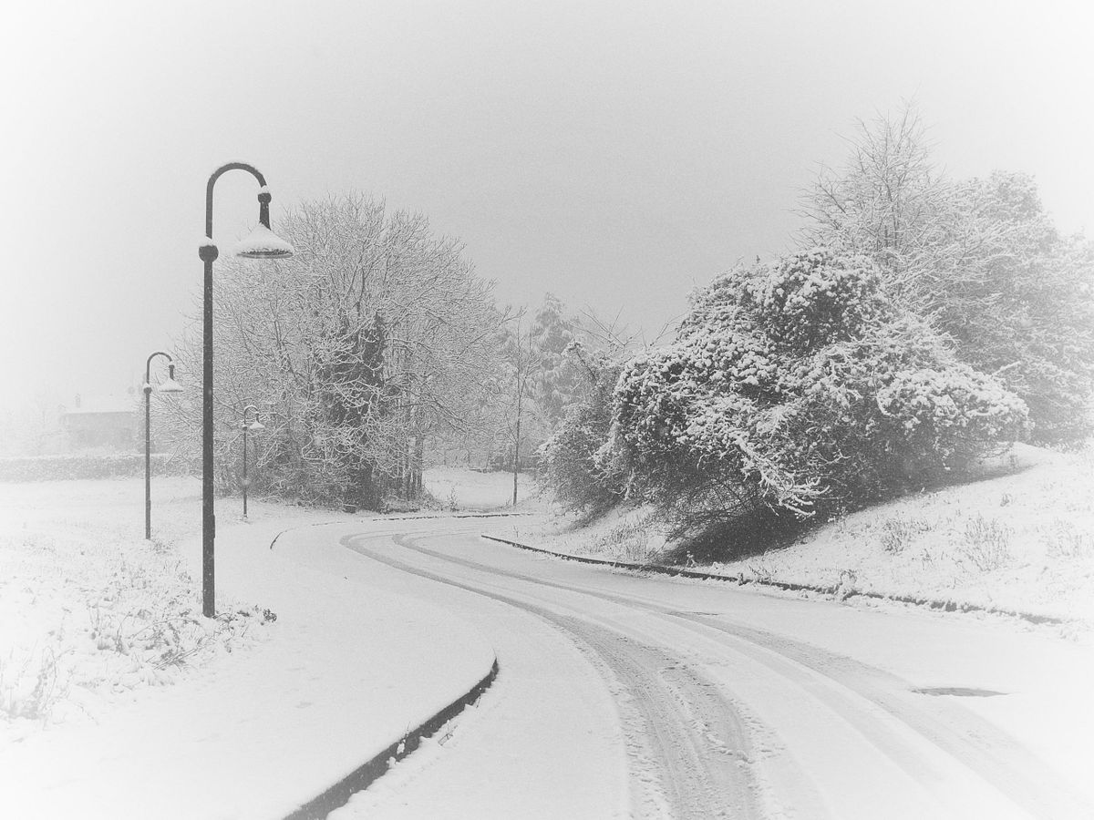 Strada innevata immersa nella calma e nel silenzio, un angolo urbano che invita a rallentare e respirare