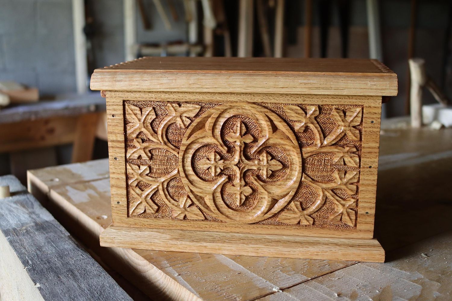 an oak box with Gothic quatrefoil, vines and leaves carved by hand to hold bourbon glasses