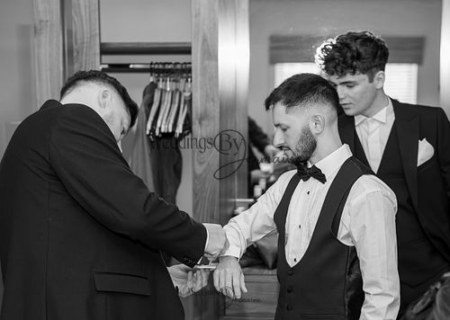 Wedding by Jermaine – black and white photo of the bride’s father helping the groom with cufflinks