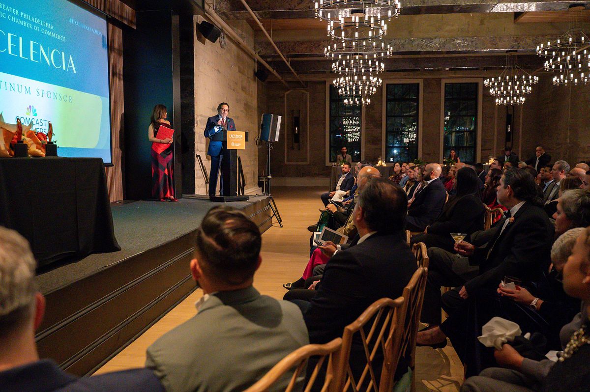 Corporate event photography capturing a keynote address during the 2025 Excelencia in Business Awards Reception in Philadelphia, highlighting leadership presence, audience engagement, and community celebration in a professional awards setting.