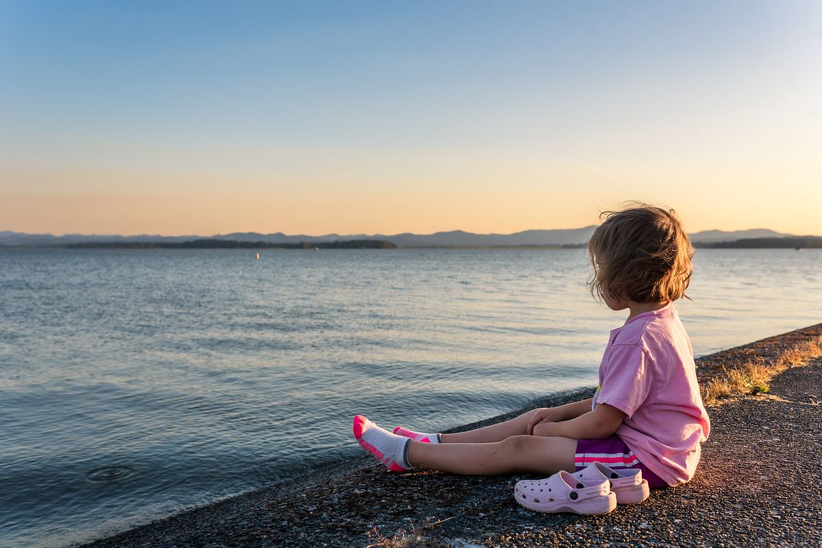 shoeless girl in all pink sitting next to lake with cranberry twp, pa newborn photographer