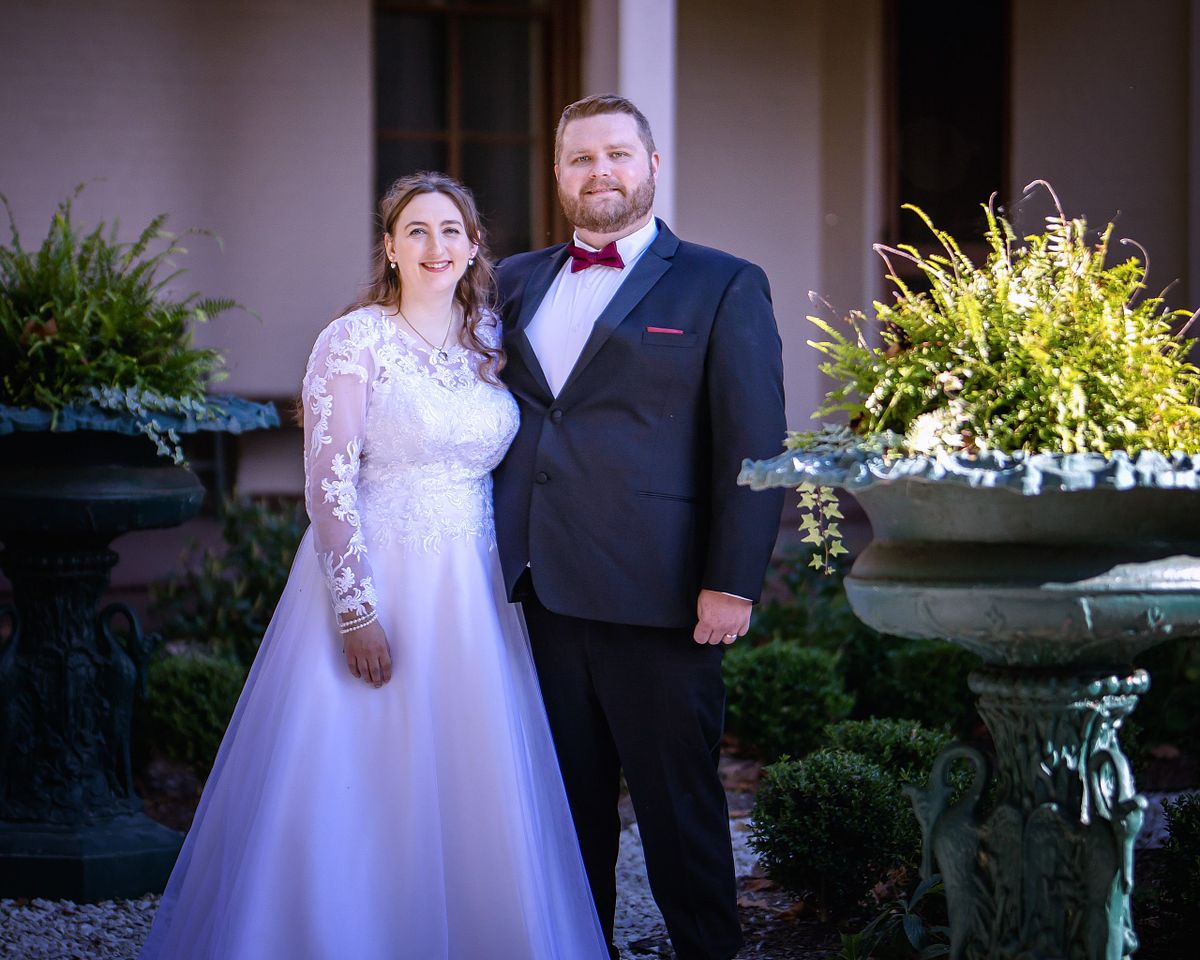 bride and groom posing in  the back of the historic victorian ross mansion in seaford, de