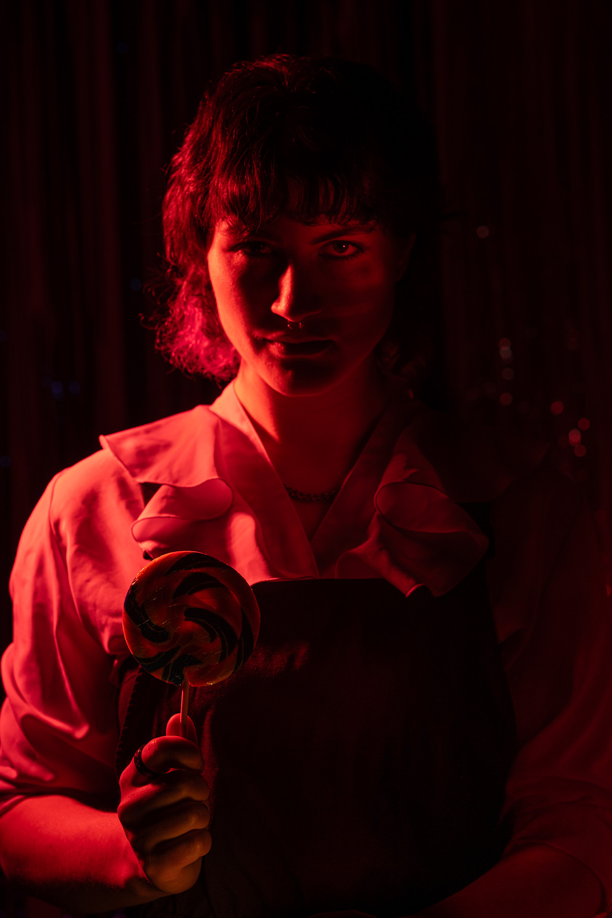 Using dramatic light to create a sinister portrait of a figure with spiral lollipop..