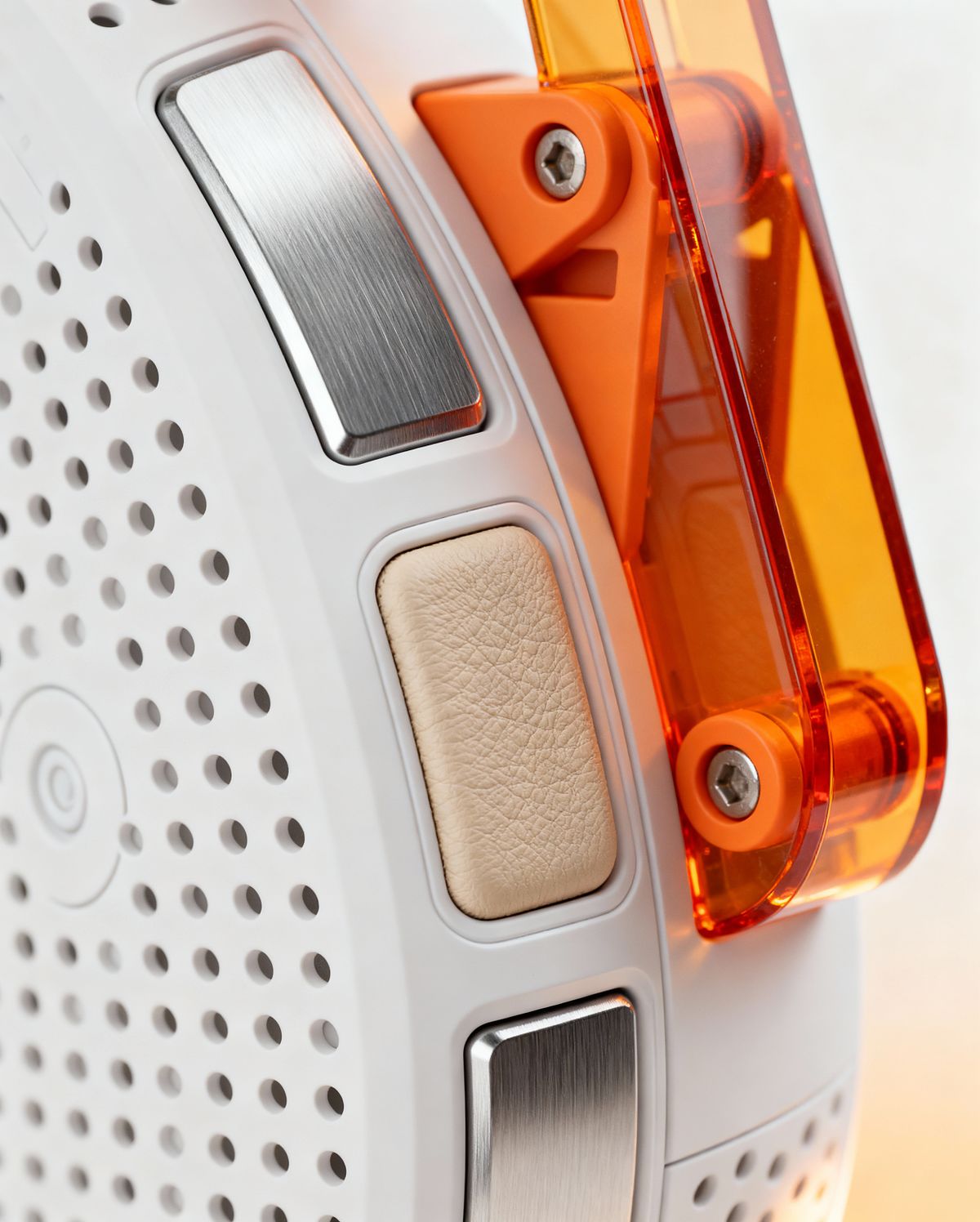 Close-up of high-end technical product with perforated white plastic, brushed aluminum, beige leather texture, and translucent orange plastic components.