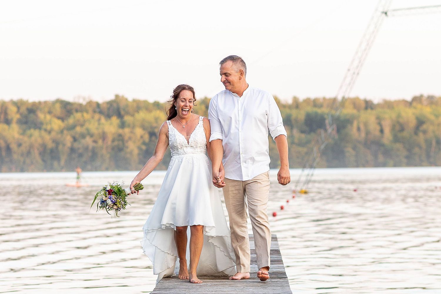 Brautpaar lachend auf einem Steg am Bleibtreesee, Brühl - Iris Sauermann Fotografie