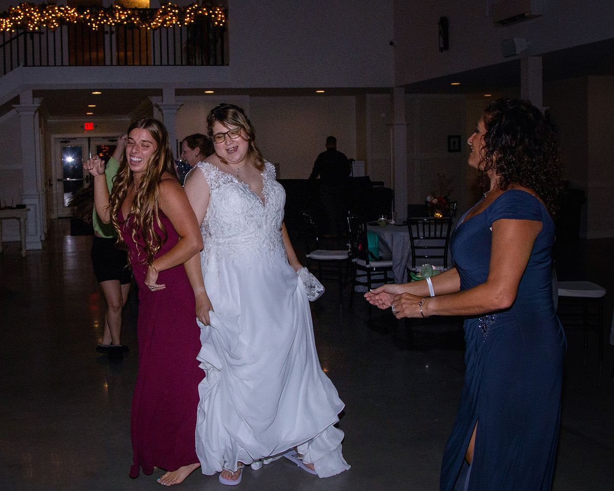 bride dancing with bridesmaid, documented with flash photography at Willowbrook, sussex county, de