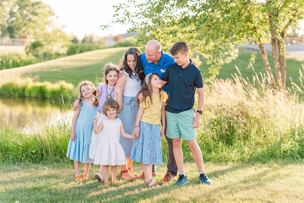 Cranberry Township Community Park family interacting and smiling near a pond in golden hour light in summer