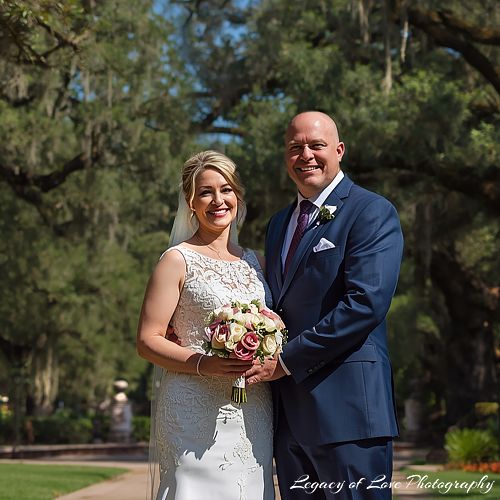 A sophisticated mature couple smiling together during their second marriage celebration in a lush outdoor setting in Florida.