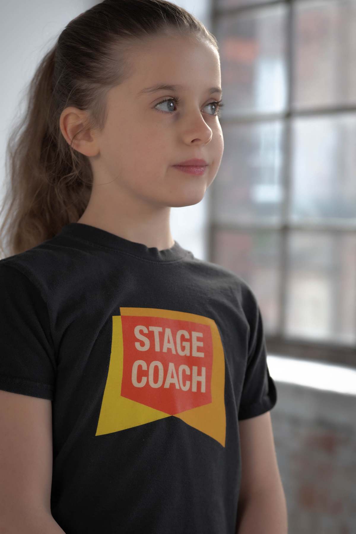 Girl in studio natural light wearing branded t-shirt, children's brand photography Northamptonshire