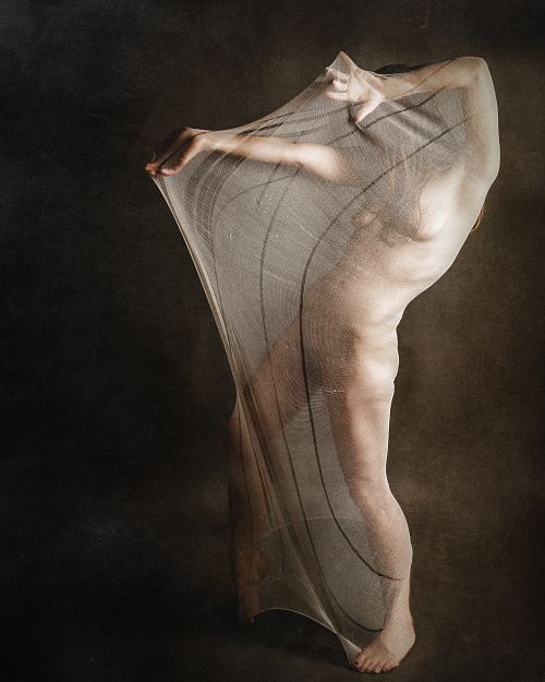 Photographie fine art d’une femme nue enveloppée dans un voile tendu, illustrant la lutte intérieure entre protection et ouverture, et la difficulté de s’exposer émotionnellement — œuvre de Pascal Yennis, Namur, Belgique.