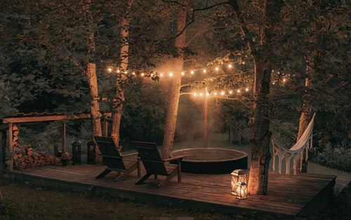 Outdoor terrace with string lights at Two Black Cabins
