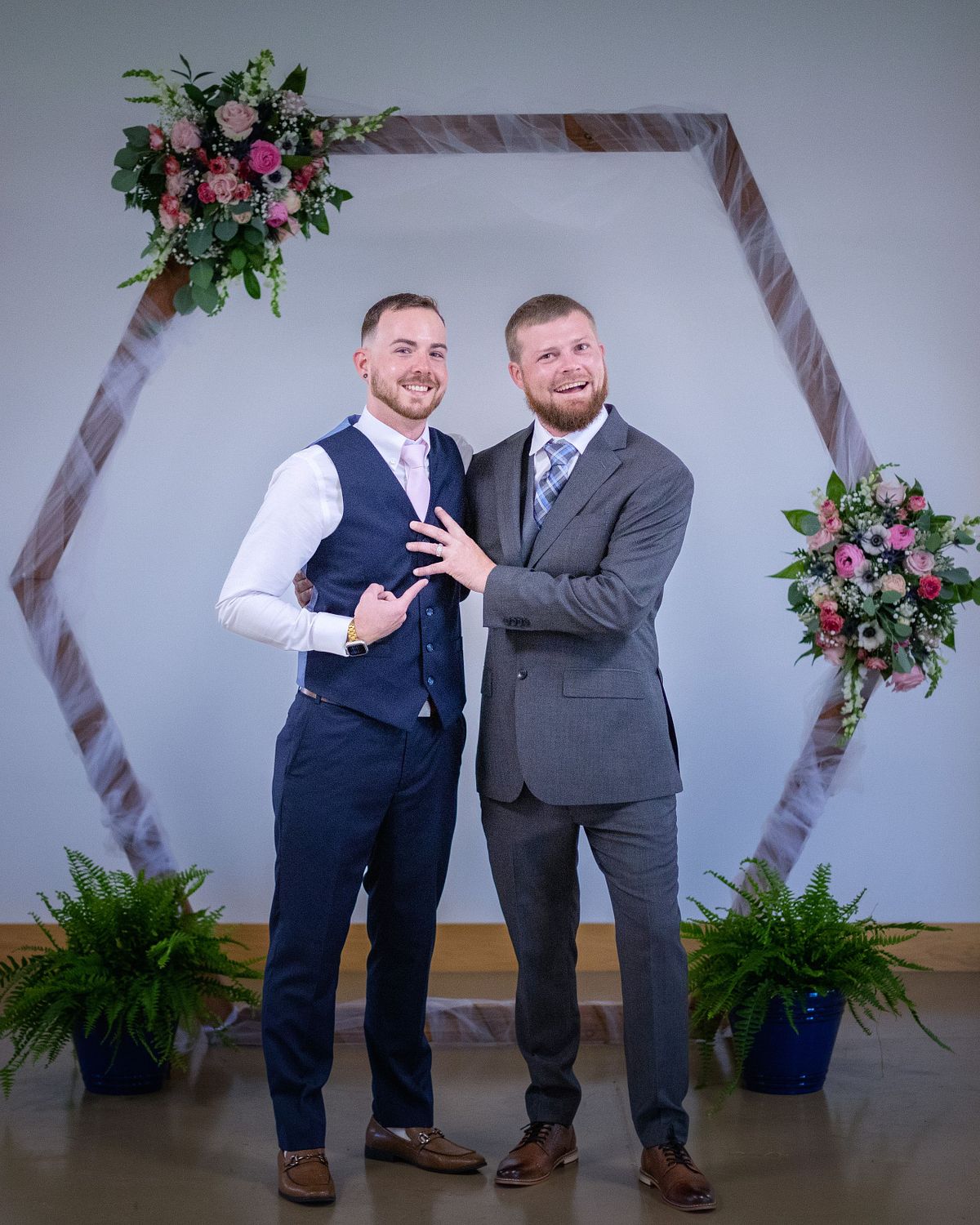 groom with his groomsman posing a fun photo with the groomsmen pointing at the grooms hand showing of his wedding ring