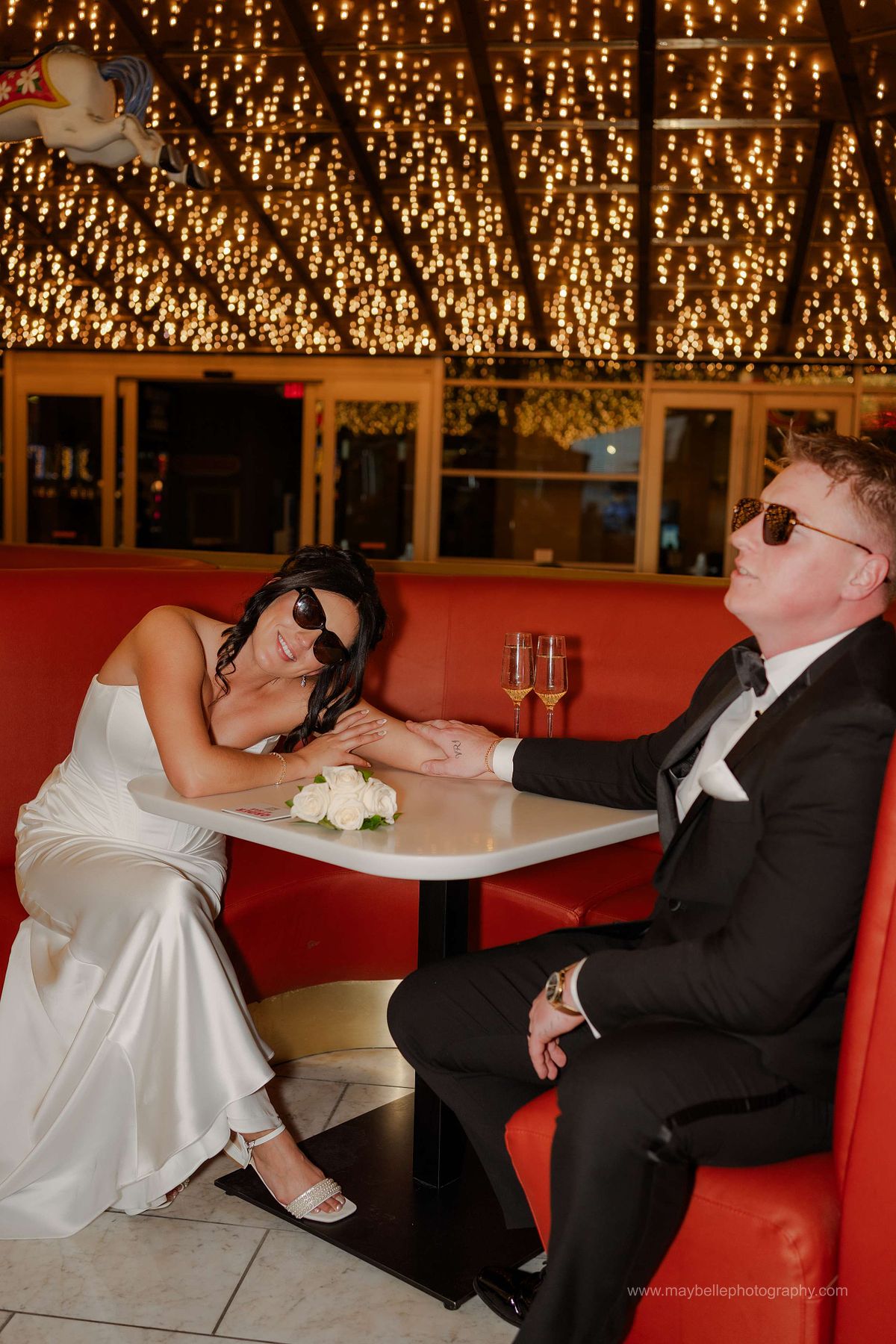 Romantic elopement photos at Carousel Bar in Downtown Las Vegas with couple celebrating with champagne