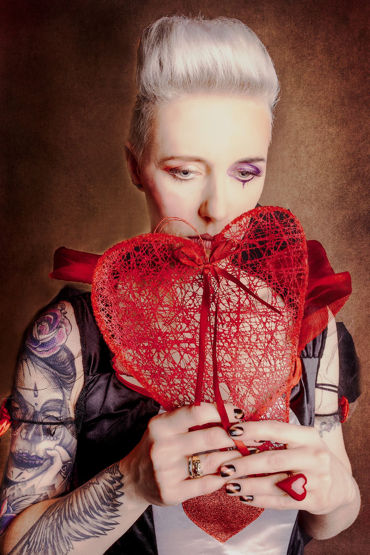 photo tarot Reine de C&oelig;ur, femme triste cach&eacute;e derri&egrave;re un c&oelig;ur dans un monde f&eacute;erique