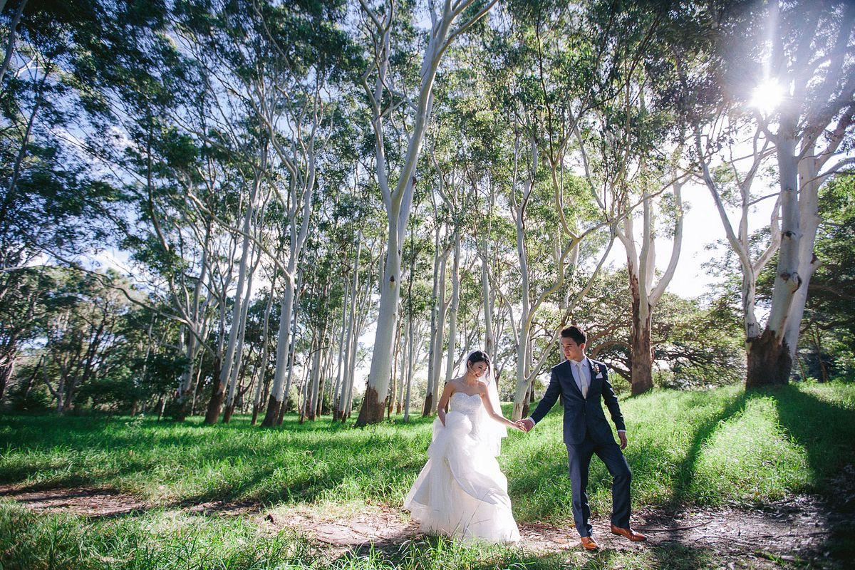 Scenic wedding photo of the newlyweds standing hand in hand with a breathtaking backdrop at Sandstone Ridge, Centennial Park.