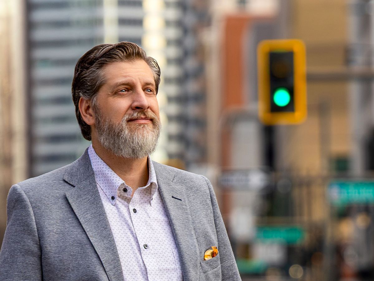 confident man looking upward in urban setting with soft afternoon light corporate headshot