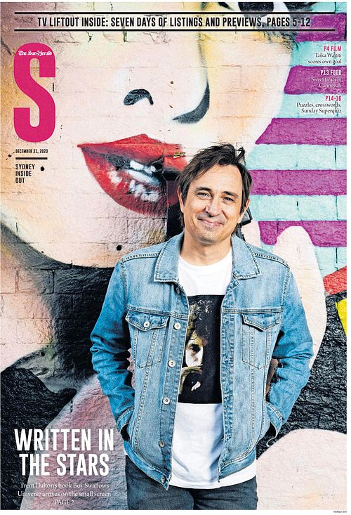 Boy Swallows Universe author Trent Dalton stands in front of iconic Red Hill Cinema wearing a denim jacket and smiling at the camera.