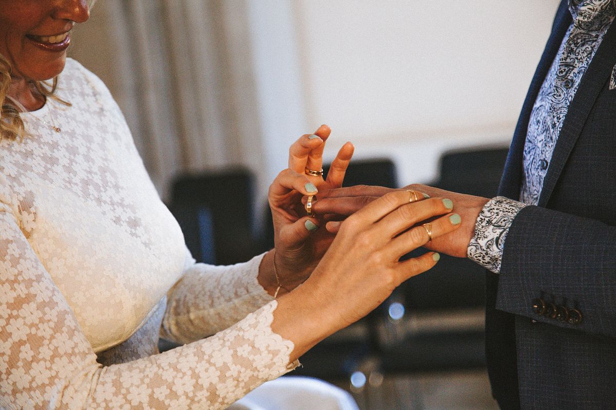 Detailaufnahme der Braut, die dem Br&auml;utigam den Ehering an den Finger steckt, Ringtausch bei der Trauung in K&ouml;ln.