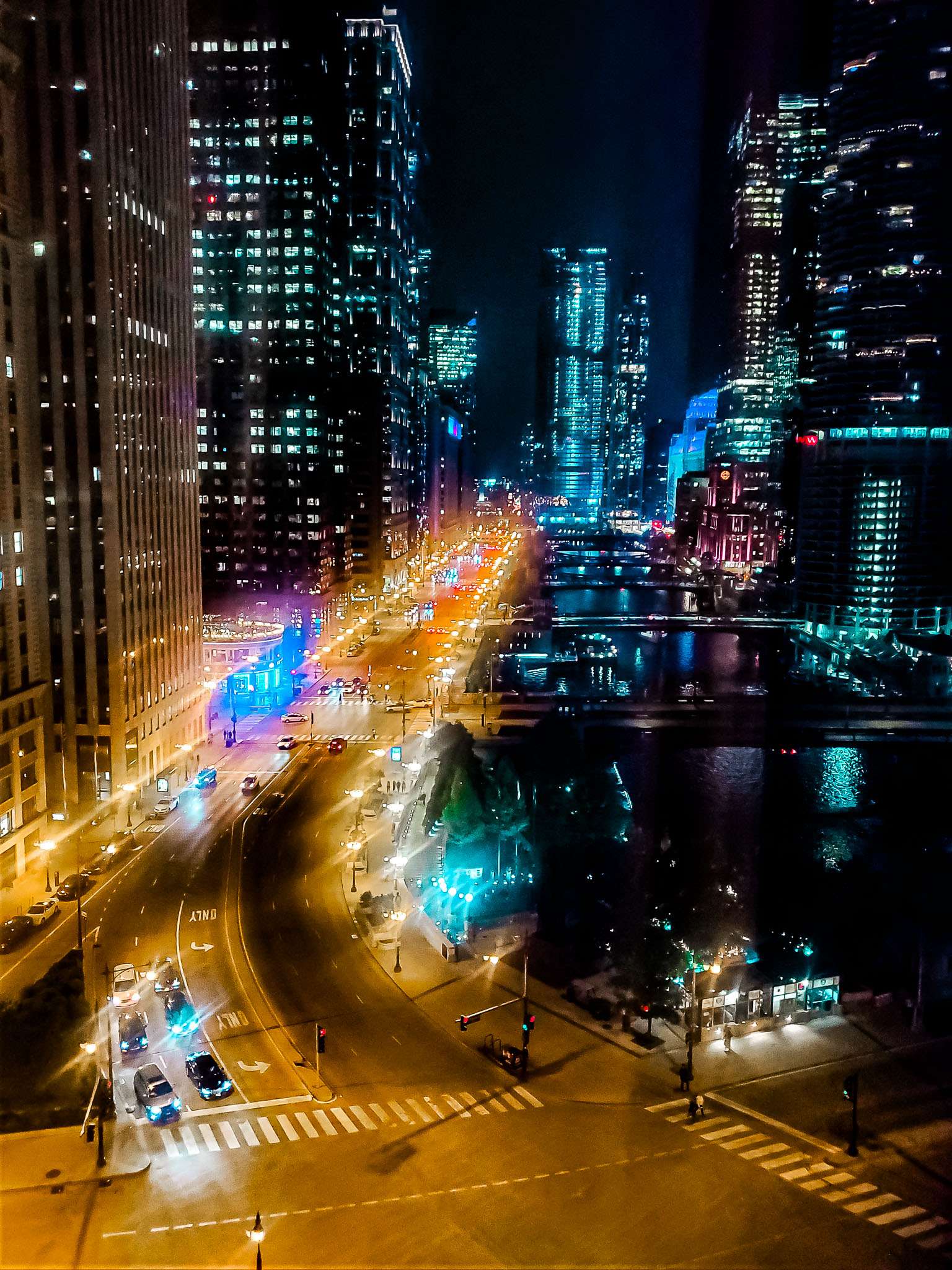 City lights glisten off the river as Chicago's architecture shines under the night sky.