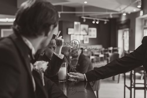 Wedding by Jermaine – black and white photo of friends enjoying a drink during the wedding celebration