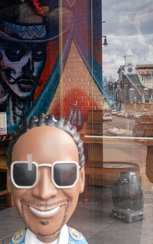 Portraits of diverse individuals with a New England street and church steeple reflected in the background.