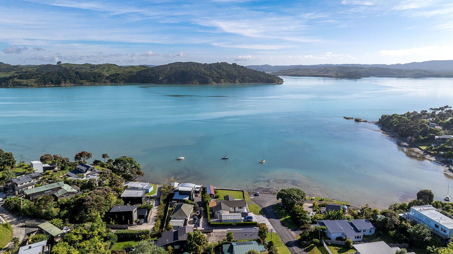 Cinematic drone photography of a luxury waterfront property in Lorenzen Bay, Raglan by Flax Cove Studio.
