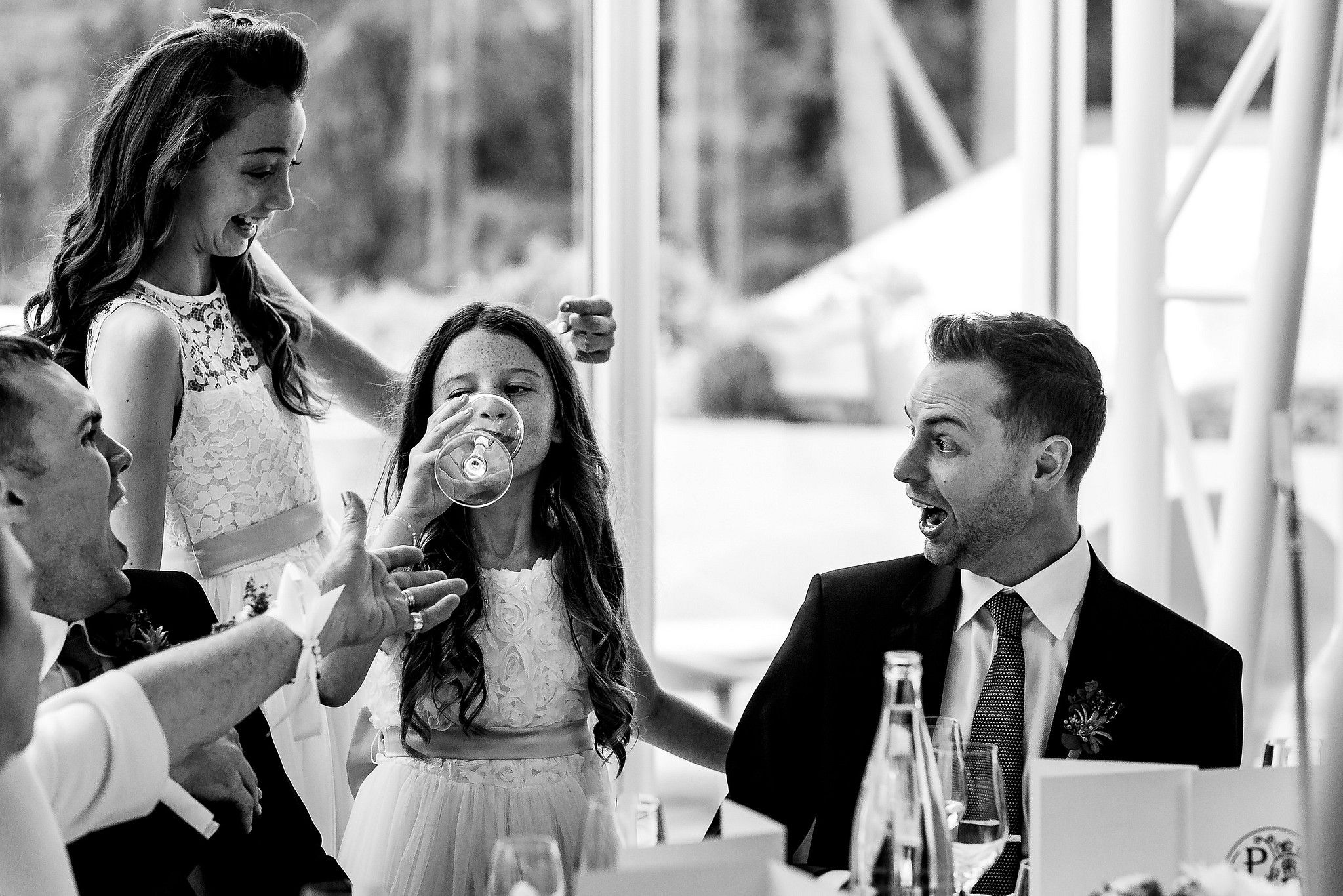 Petite fille qui boit dans le verre du mari&eacute; qui rigole captur&eacute; par S&eacute;bastien CLAVEL photographe de Mariage &agrave; Lyon et Gen&egrave;ve
