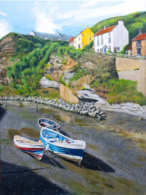Three boats, waiting for the tide to come into Staithes harbour inlet.