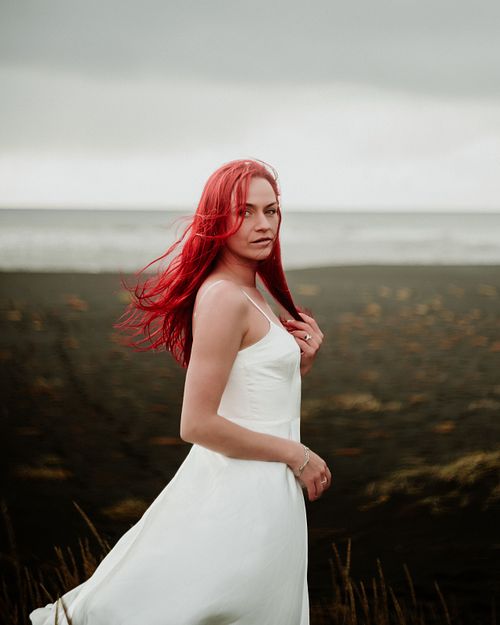 Elegant feminine portrait on black sand beach in Iceland