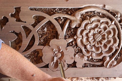 Dogwood blossom being carved by hand in the walnut door panel