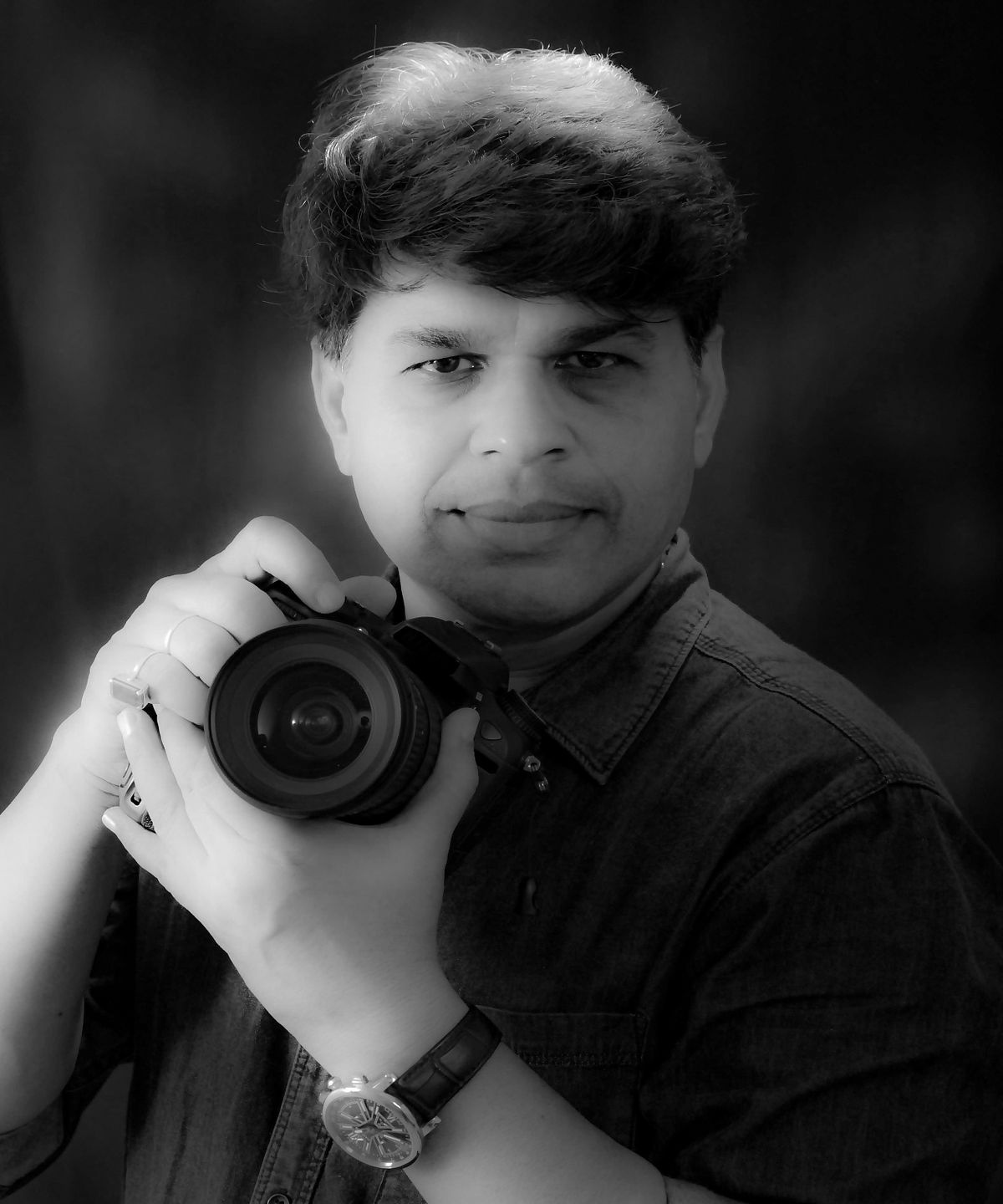 A male photographer holding a camera in his hands to shoot