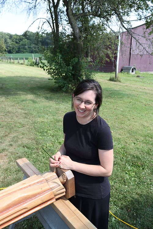 Kelly Baker cleaning a statue with compressed air and brushes