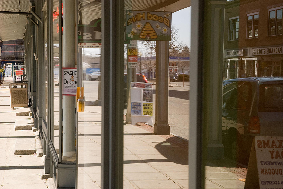 Reflection of street scene in Ayer main street store windows