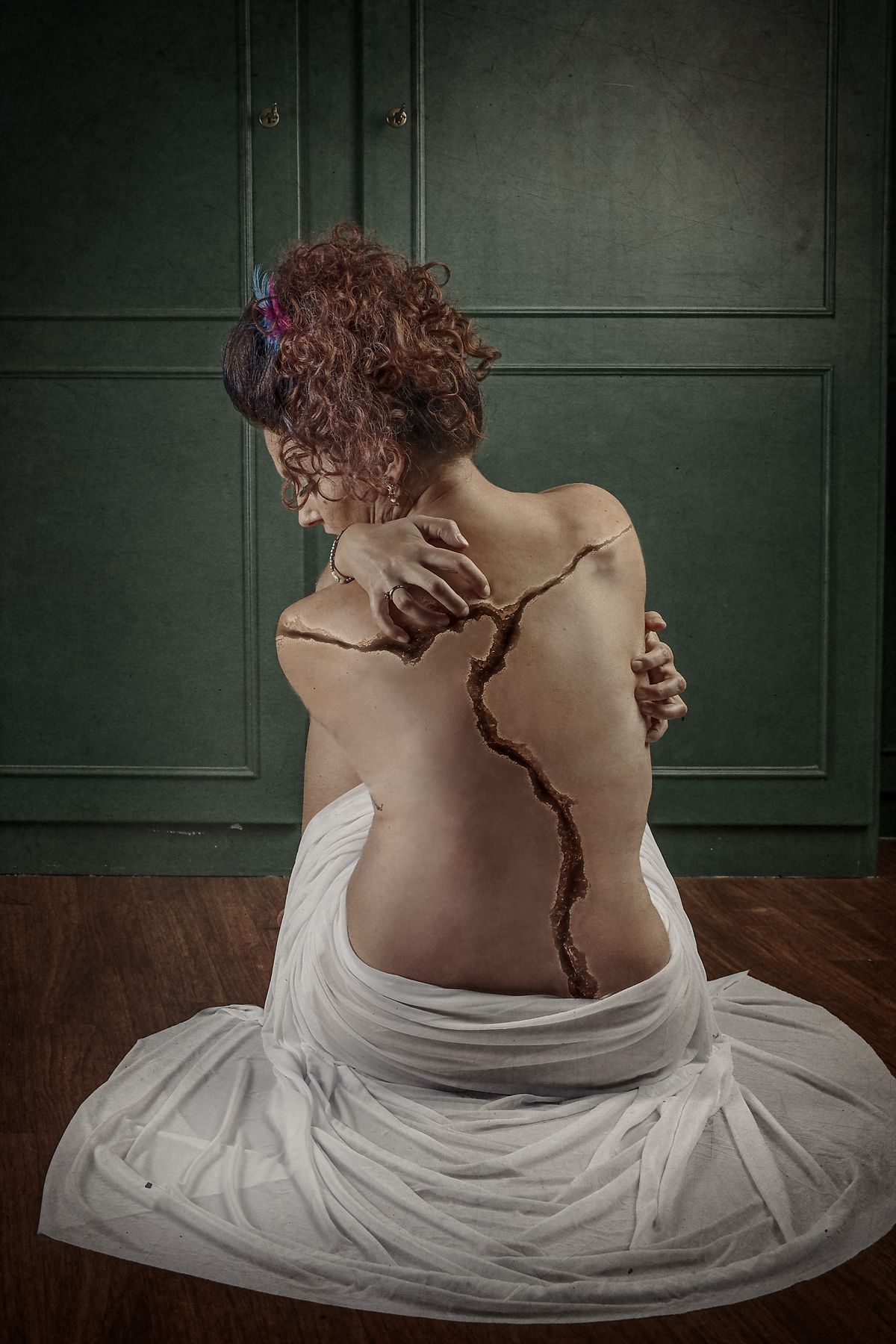 photo tarot Broken, femme vue de dos avec fissure dans le dos et regard baissé, évoquant douleur et résilience
