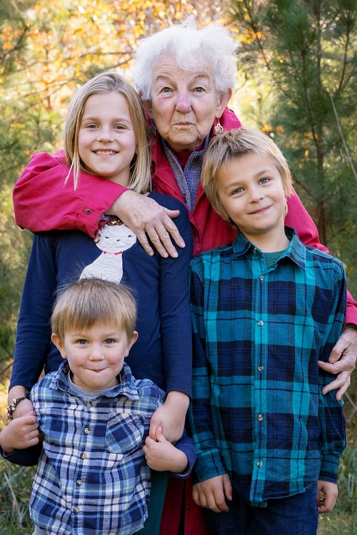 A multigenerational family photographed against the fall foliage in Dr. Martin Luther King Jr. Park in Carrboro, NC